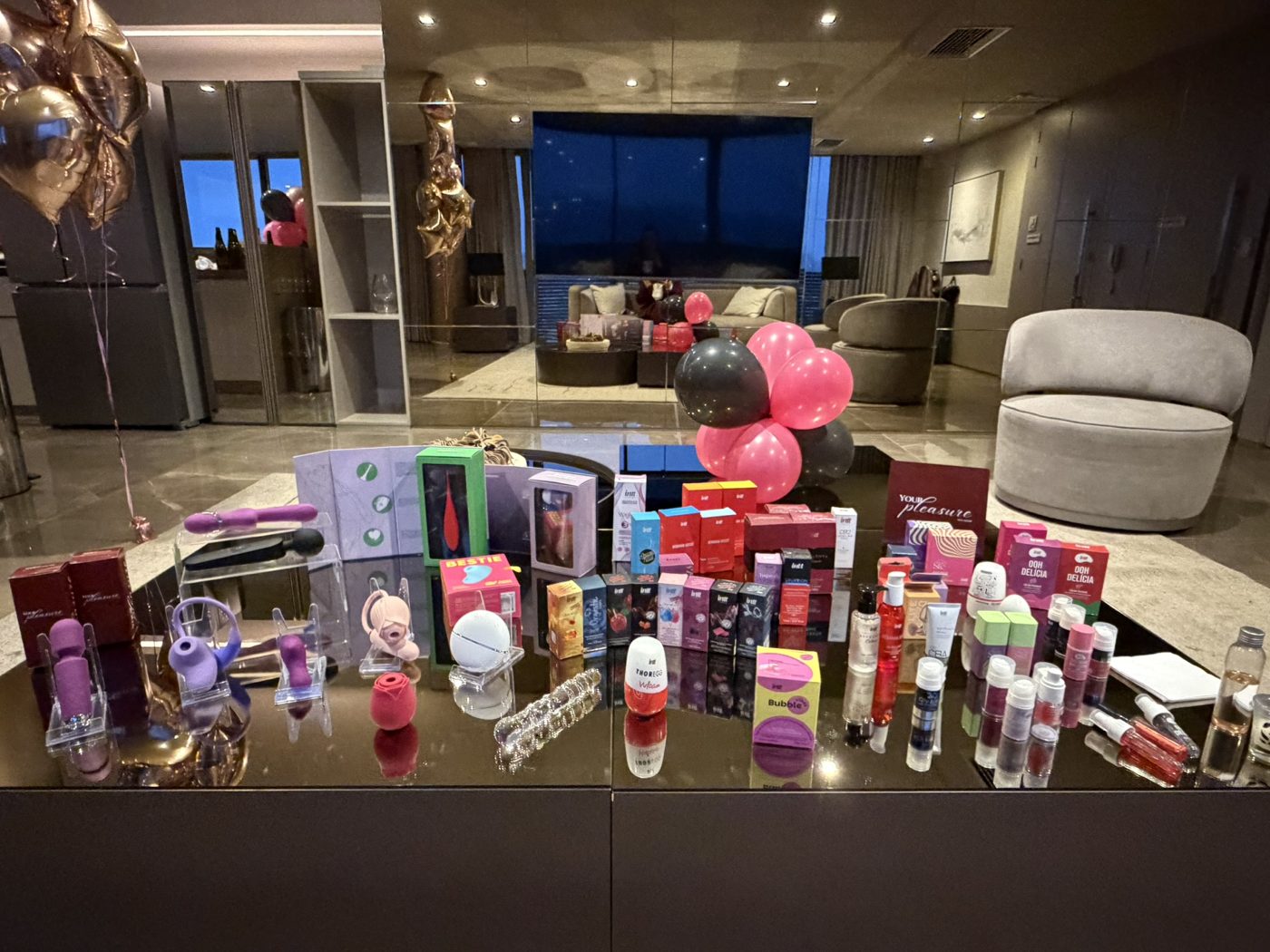 Vitrine da Your Pleasure montada em um evento, com vibradores, cosméticos e balões